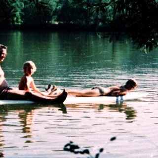 Two people relaxing on a small boat in calm water.