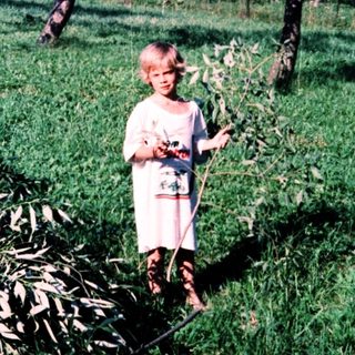 Child holding flowers in a garden.