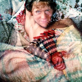 Person lying in bed with colorful bedding.