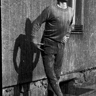 Young man posing confidently on balcony railing.