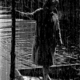 Silhouette of person standing in rain.