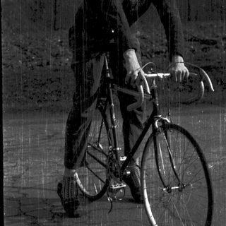 Man riding vintage road bicycle outdoors.