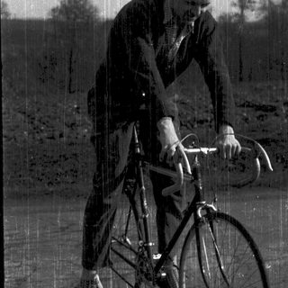 Man riding vintage road bicycle outdoors.