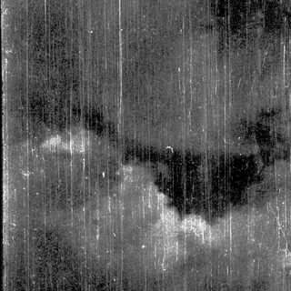 Rainy night view through vertical window panes.