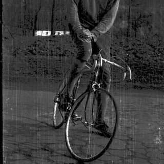 Young man smiling while sitting on a road bike.
