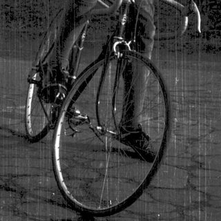 Young man smiling while sitting on a road bike.