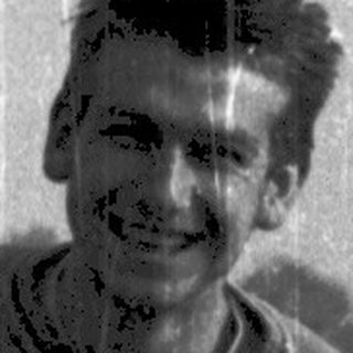 Young man smiling while sitting on a road bike.