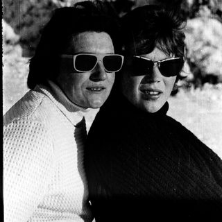 Two women wearing sunglasses and casual attire outdoors.