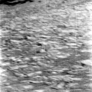 Lunar surface with craters and rugged terrain.