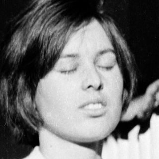 A person singing or speaking with eyes closed.