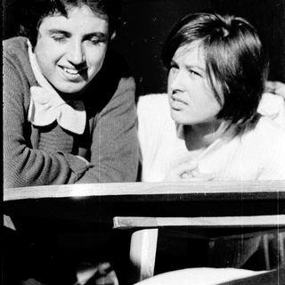 Two people smiling and interacting indoors.