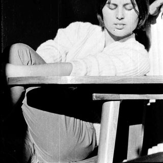 A person sitting relaxed with eyes closed.