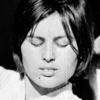 A person sitting relaxed with eyes closed.