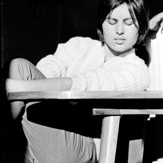 A person sitting relaxed with eyes closed.