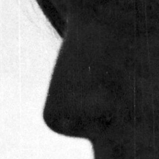 Silhouette of person with short hair outdoors.