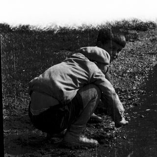 Person digging or planting in a trench.