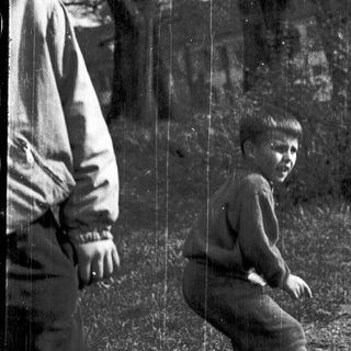 Two people sitting outdoors near trees.