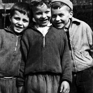 Three cheerful boys posing together outdoors.