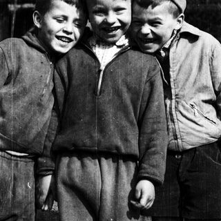 Three cheerful boys posing together outdoors.