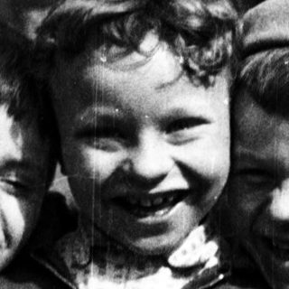 Three cheerful boys posing together outdoors.