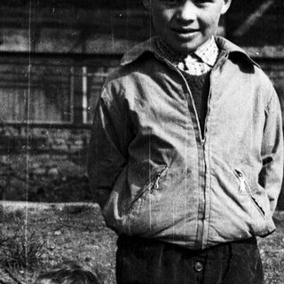 Three boys in early 20th-century clothing outdoors.