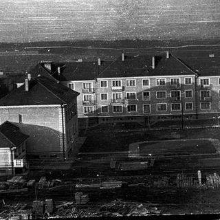 Large multi-story building complex with industrial surroundings.