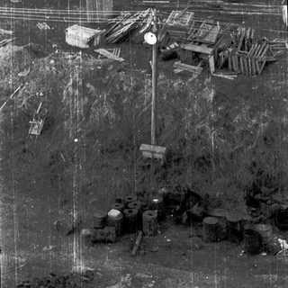 Aerial view of industrial construction site with cranes and materials.