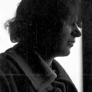 Silhouette of person looking out in rain.