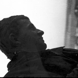 Sculpture of weary soldier in contemplative pose.