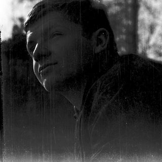 A person smiling through rain on a window.