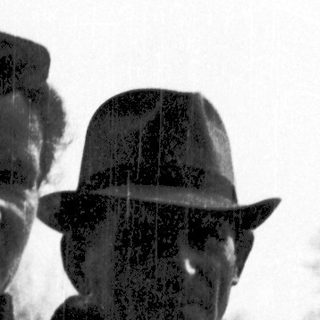 Two men in vintage attire standing outdoors.