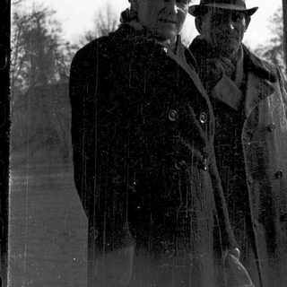 Two men in vintage attire standing outdoors.