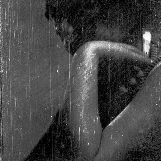 Silhouette of person sitting in rain.