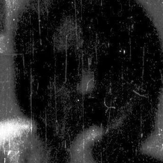 Silhouette of person sitting alone in rain.
