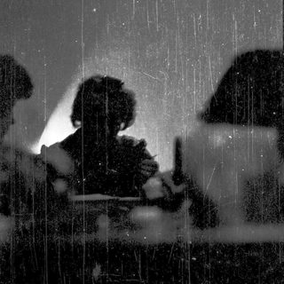Silhouette of person working indoors during heavy rain.