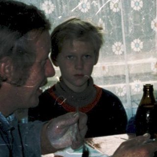 Family gathering around a table eating indoors.