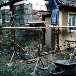 Construction workers repairing or rebuilding a brick chimney.