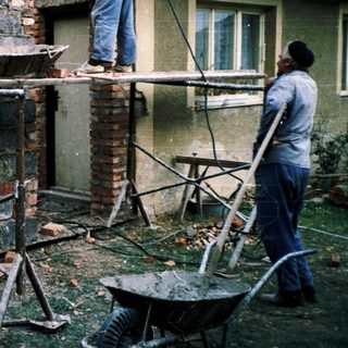 Construction workers repairing or rebuilding a brick chimney.