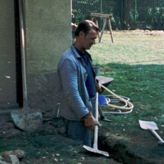 Men working on garden maintenance with tools.