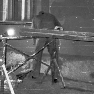 People repairing damaged street infrastructure at night.