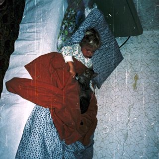 Person sleeping with cat on bed.