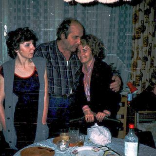 Family celebrating birthday indoors with cake and candles.