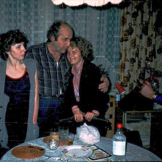 Family celebrating birthday indoors with cake and candles.