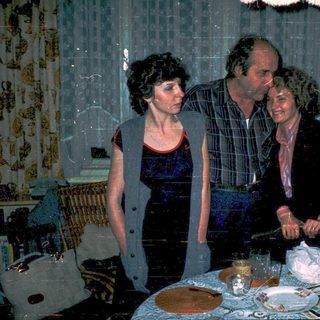 Family celebrating birthday indoors with cake and candles.
