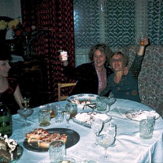 Celebratory gathering with cake, glasses, and smiling women.