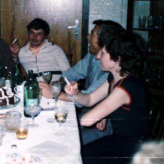Group enjoying meal and drinks at a festive indoor gathering.