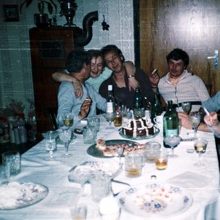 Group enjoying meal and drinks at a festive indoor gathering.