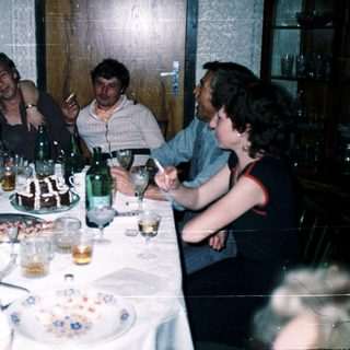 Group enjoying meal and drinks at a festive indoor gathering.