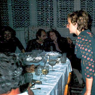 Social gathering with people seated at a table.