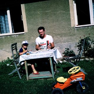 Family picnic outdoors near a house.